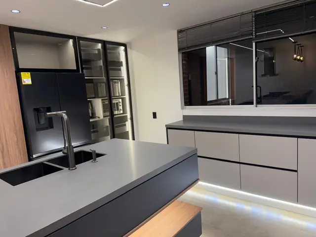 Cocina con isla de mesón oscuro y detalles en madera