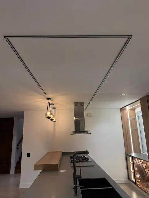 Cocina terminada con mesón, campana y lámparas